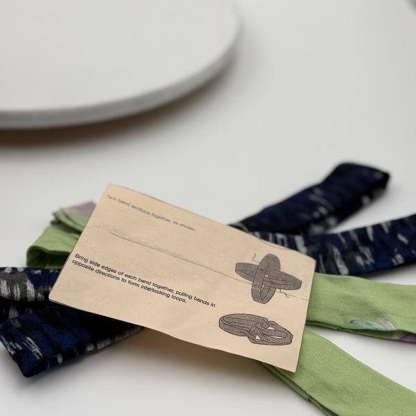 Handgemaakte chemo muts Buffy zacht groen met bloemen en blauw zwart gebreid maat M