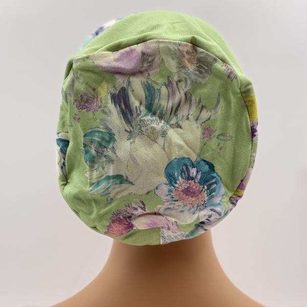 Handgemaakte chemo muts Buffy zacht groen met bloemen en blauw zwart gebreid maat M