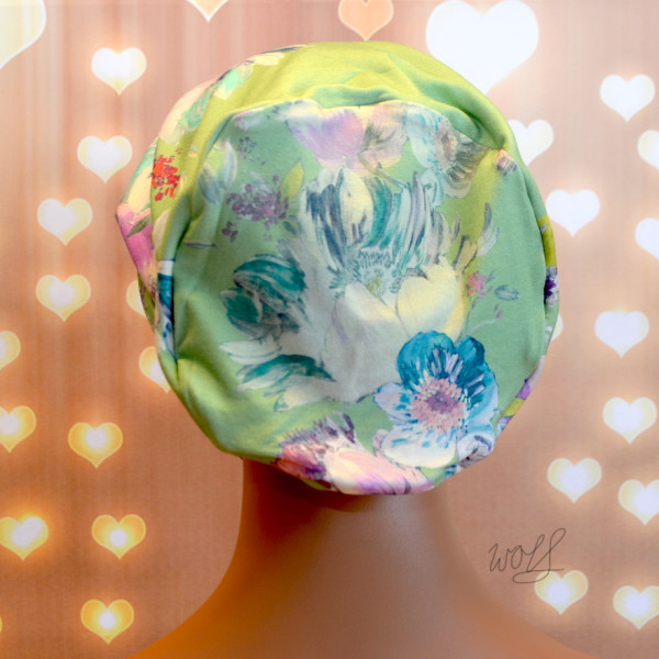 Handgemaakte chemo muts Buffy zacht groen met bloemen en blauw zwart gebreid maat M